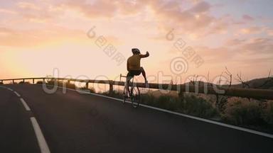 一位戴着头盔和运动器材的职业自行车手站在山的边缘，可以看到美丽的景色。